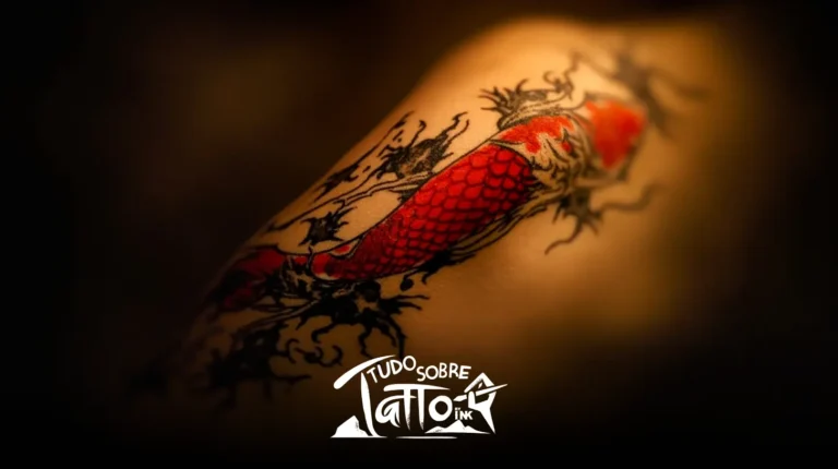 Uma tatuagem de uma carpa vermelha com detalhes em tinta preta é exibida na pele de uma pessoa, com o logotipo "Tudo Sobre Tattoo Ink" na parte inferior.